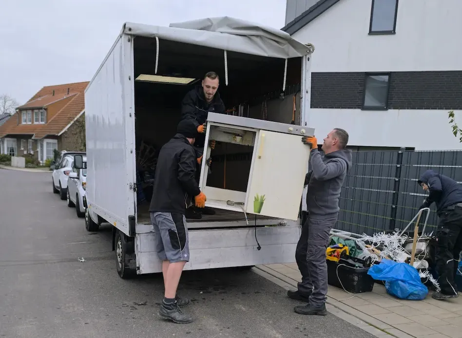 Team von HadiCo beim Umzug – Möbel werden sorgfältig in den Transporter verladen, professionelle Umzugshelfer im Einsatz
